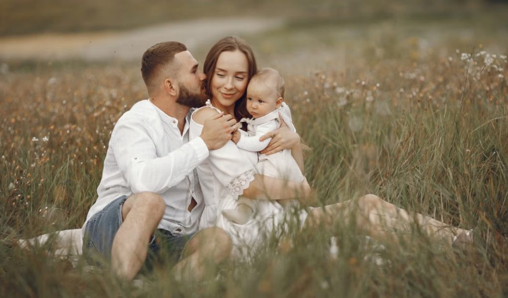 Happy family enjoying quality time in a serene meadow setting.
